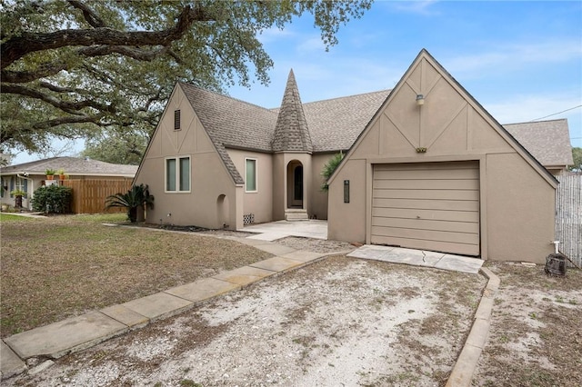 view of front of property featuring fence, driveway, an attached garage, and stucco siding