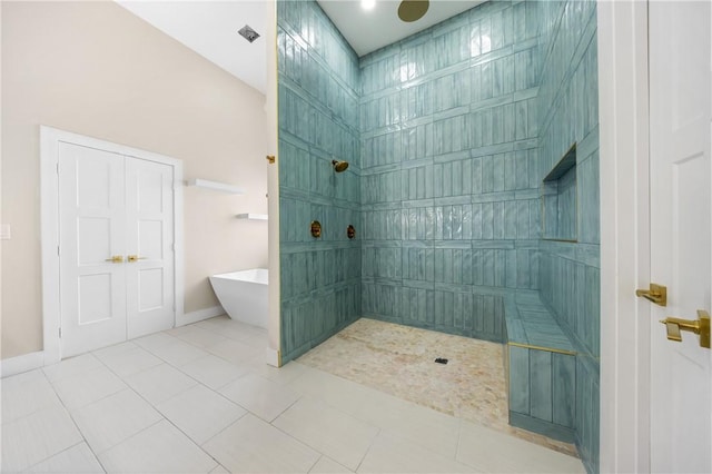 bathroom with a freestanding tub, baseboards, tile patterned flooring, and a tile shower