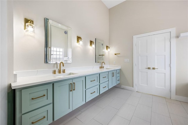 bathroom with double vanity, baseboards, and a sink