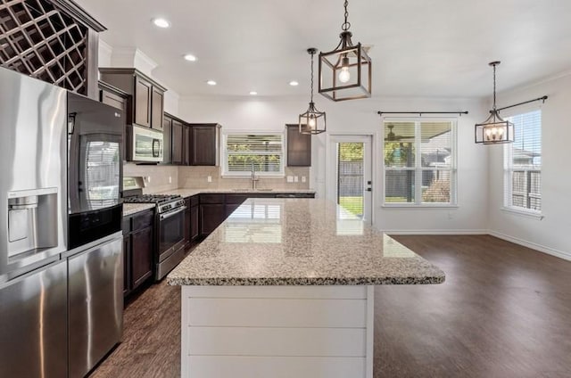 kitchen featuring a sink, tasteful backsplash, a center island, appliances with stainless steel finishes, and dark brown cabinets