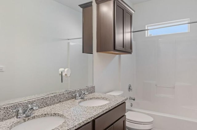 bathroom with a sink, toilet, double vanity, and shower / tub combination