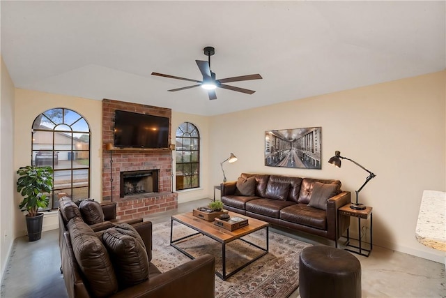 living room featuring concrete flooring, ceiling fan, and a fireplace