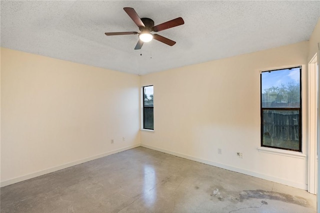 spare room with ceiling fan, a textured ceiling, and a healthy amount of sunlight