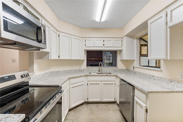 kitchen featuring sink, stainless steel appliances, white cabinets, and light stone countertops