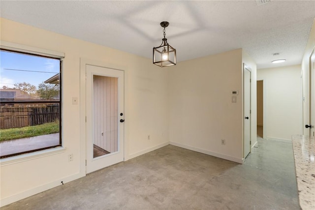 unfurnished dining area featuring a textured ceiling