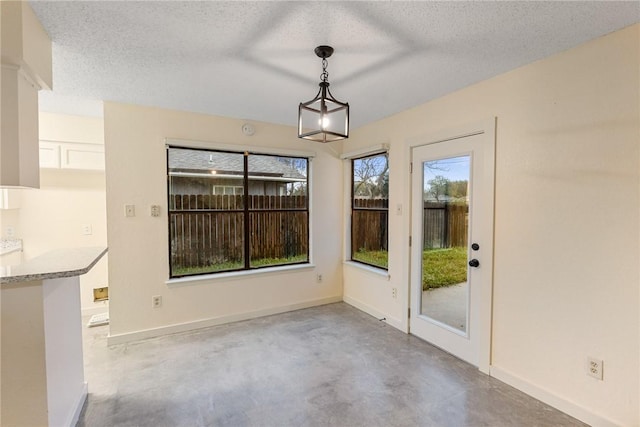 unfurnished dining area featuring concrete flooring and a textured ceiling