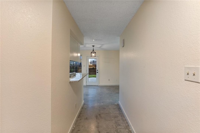 hallway with a textured ceiling