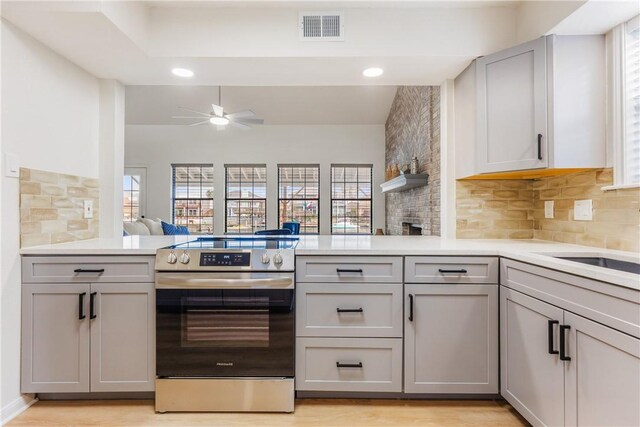 kitchen featuring electric stove, light countertops, visible vents, and gray cabinetry