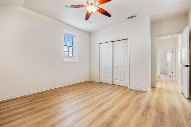 unfurnished bedroom with light wood-style flooring, a closet, visible vents, and baseboards