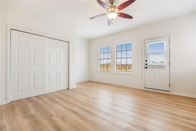 unfurnished bedroom with light wood-style floors, ceiling fan, baseboards, and a closet