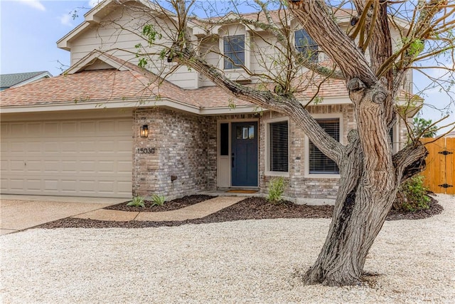 view of front of home with a garage, driveway, brick siding, and roof with shingles