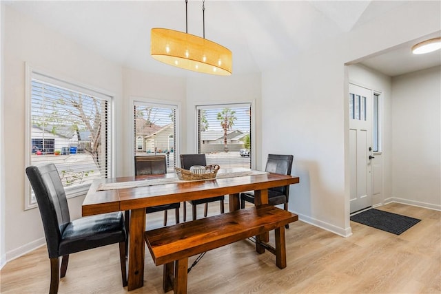 dining area with light wood-style floors, a chandelier, and baseboards