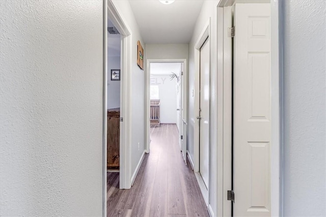 109 Misty Ln, Aransas Pass, TX 78336 - hall with wood finished floors, a textured wall, and baseboards