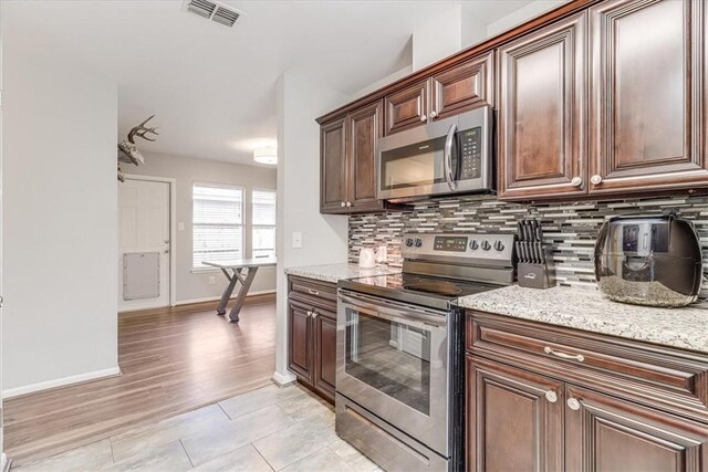 109 Misty Ln, Aransas Pass, TX 78336 - kitchen with stainless steel appliances, baseboards, tasteful backsplash, and light stone countertops