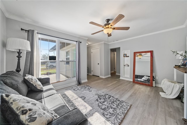 living area with a ceiling fan, crown molding, baseboards, and wood finished floors