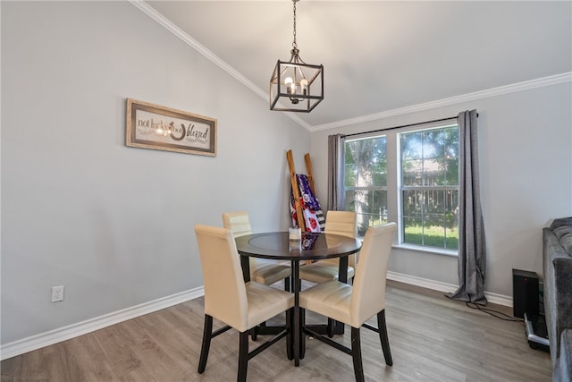 dining room with a chandelier, hardwood / wood-style floors, vaulted ceiling, and ornamental molding