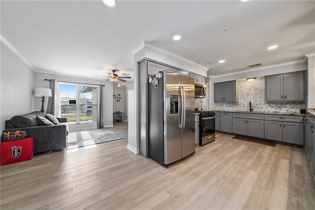 kitchen featuring gray cabinetry, appliances with stainless steel finishes, crown molding, and light hardwood / wood-style flooring