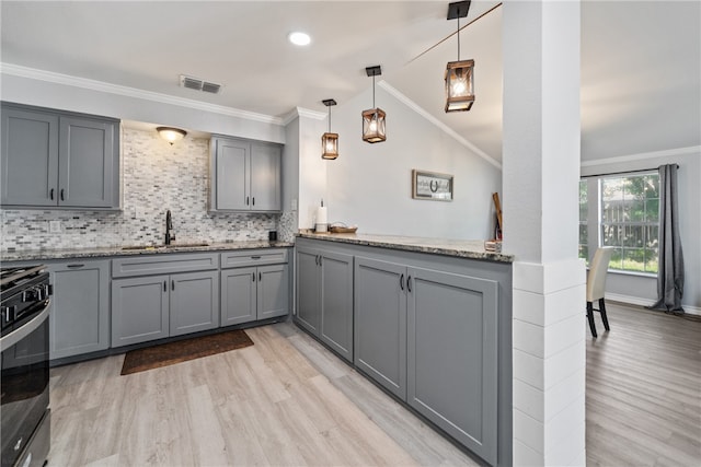 kitchen with ornamental molding, gray cabinets, pendant lighting, sink, and stainless steel range oven