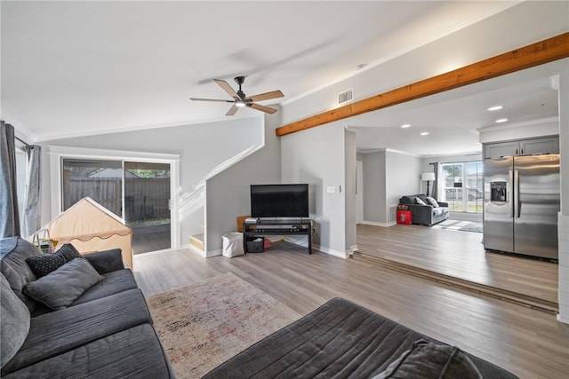 living room with an inviting chandelier, vaulted ceiling, crown molding, and light hardwood / wood-style flooring