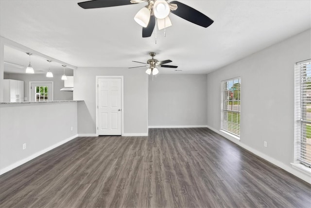 unfurnished living room with ceiling fan and dark hardwood / wood-style floors