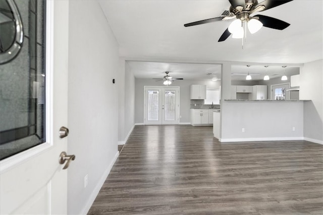 unfurnished living room featuring french doors, dark wood-type flooring, and ceiling fan