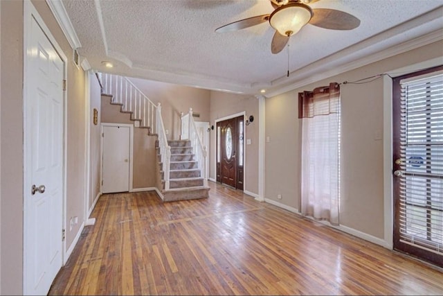 entryway with a textured ceiling, hardwood / wood-style flooring, and ceiling fan