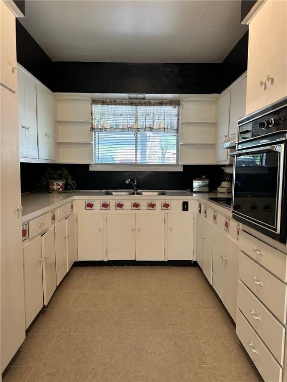 919 W W Ave Unit G, Kingsville, TX 78363 - kitchen featuring open shelves, oven, white cabinetry, and tasteful backsplash