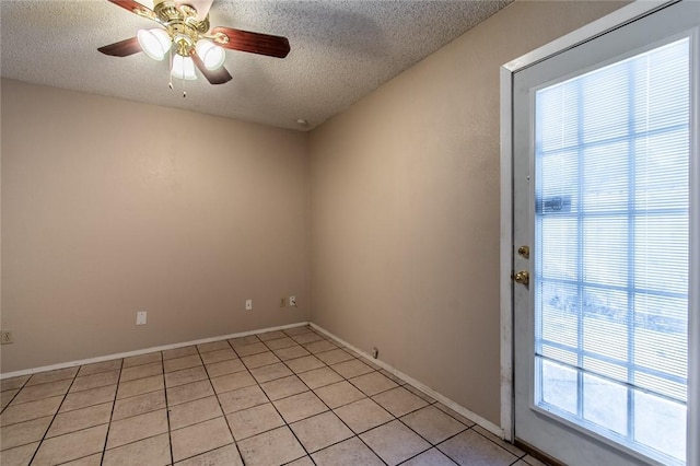 tiled spare room with a textured ceiling and ceiling fan