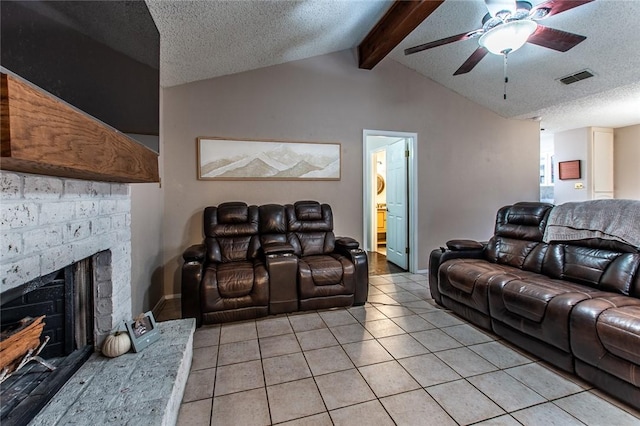 living room with ceiling fan, a brick fireplace, vaulted ceiling with beams, a textured ceiling, and light tile patterned floors