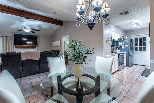 tiled dining space featuring a textured ceiling, ceiling fan with notable chandelier, and vaulted ceiling with beams