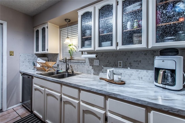 kitchen featuring decorative light fixtures, sink, white cabinetry, and black dishwasher