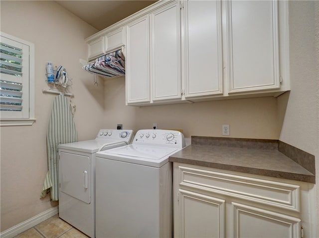 washroom featuring cabinets, light tile patterned floors, and washing machine and dryer