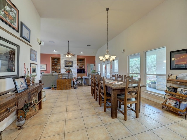 dining room with built in features, light tile patterned floors, ceiling fan with notable chandelier, and high vaulted ceiling