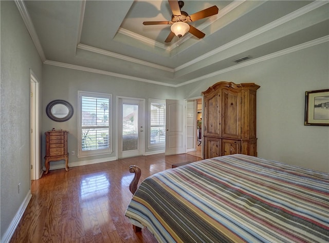 bedroom with access to exterior, a tray ceiling, ceiling fan, crown molding, and light hardwood / wood-style flooring