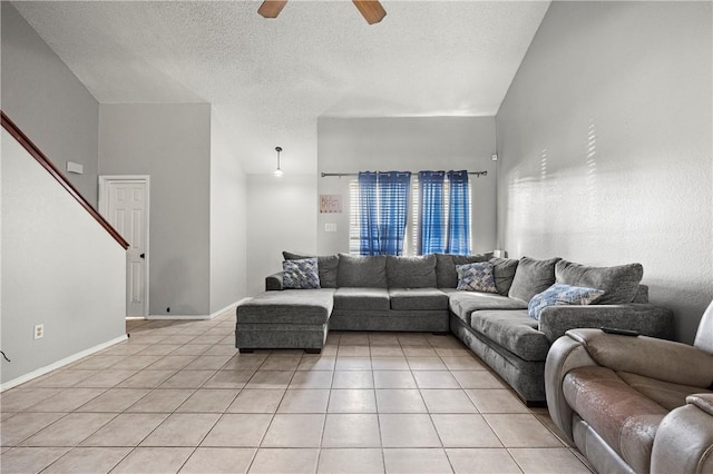 living room featuring a textured ceiling, vaulted ceiling, ceiling fan, and light tile patterned flooring