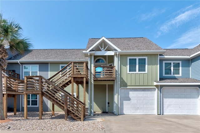 view of front of house featuring roof with shingles, a garage, board and batten siding, stairway, and driveway