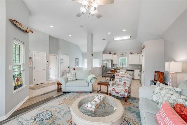 living area with recessed lighting, ceiling fan, a wealth of natural light, and vaulted ceiling
