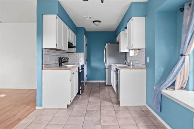 2809 Vancouver Dr, Corpus Christi, TX 78414 - kitchen with appliances with stainless steel finishes, decorative backsplash, white cabinets, and light countertops