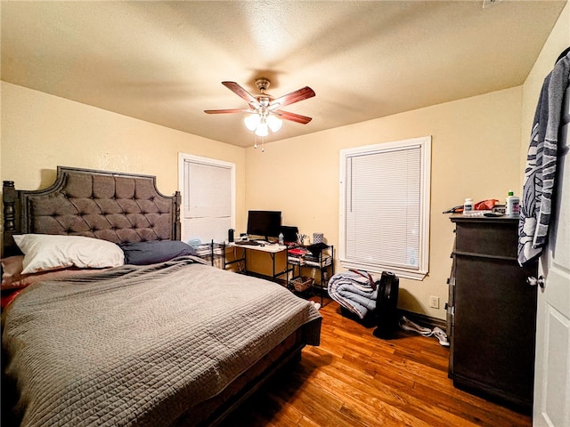 bedroom featuring hardwood / wood-style floors, a textured ceiling, and ceiling fan