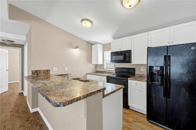 kitchen featuring black appliances, white cabinetry, kitchen peninsula, and sink