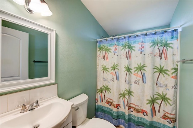 bathroom featuring a shower with shower curtain, decorative backsplash, vanity, toilet, and lofted ceiling