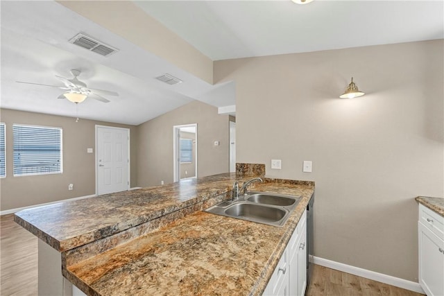 kitchen with kitchen peninsula, white cabinetry, ceiling fan, and sink