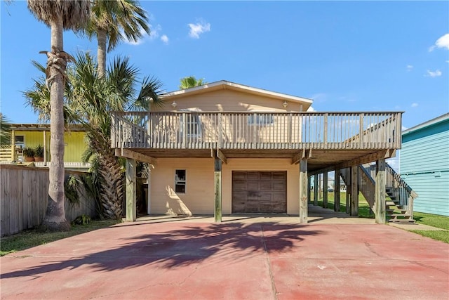 rear view of house featuring a garage and a deck