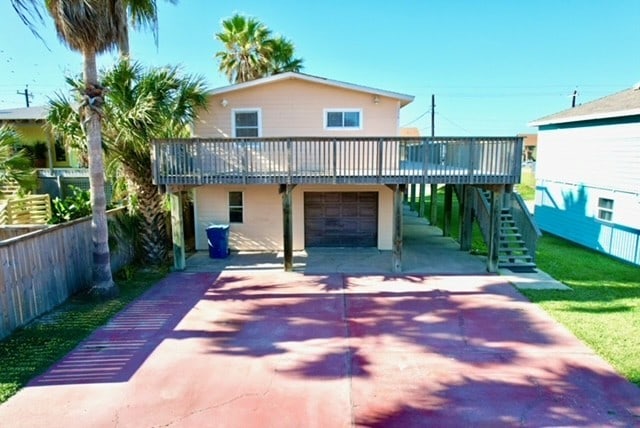 back of house featuring a deck and a garage