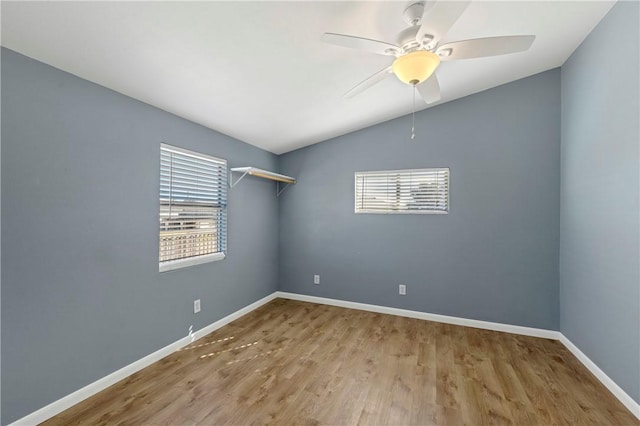 empty room with hardwood / wood-style floors, vaulted ceiling, and ceiling fan