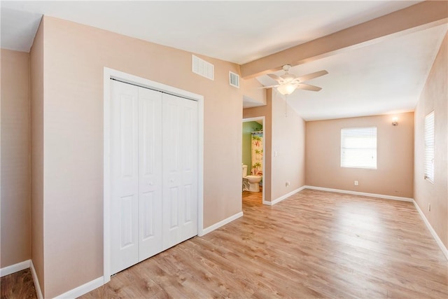 unfurnished bedroom featuring vaulted ceiling with beams, a closet, light hardwood / wood-style flooring, and ceiling fan