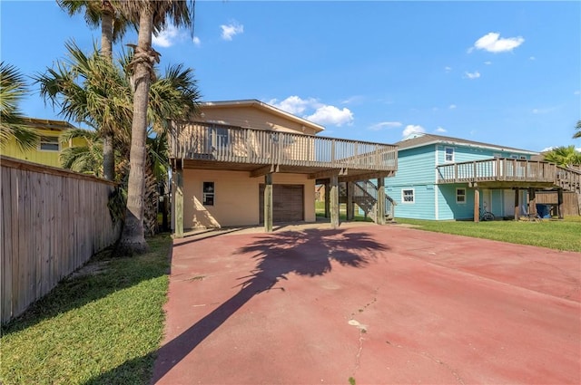 view of front of home featuring a garage, a deck, and a front lawn