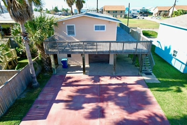 back of house with a wooden deck and a patio