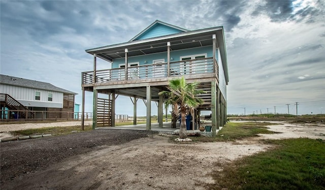 exterior space featuring stairs, a carport, a porch, and driveway