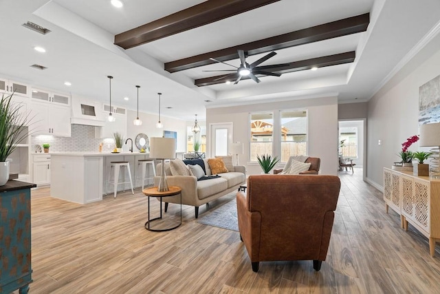 living area with a ceiling fan, beam ceiling, visible vents, and light wood-style flooring